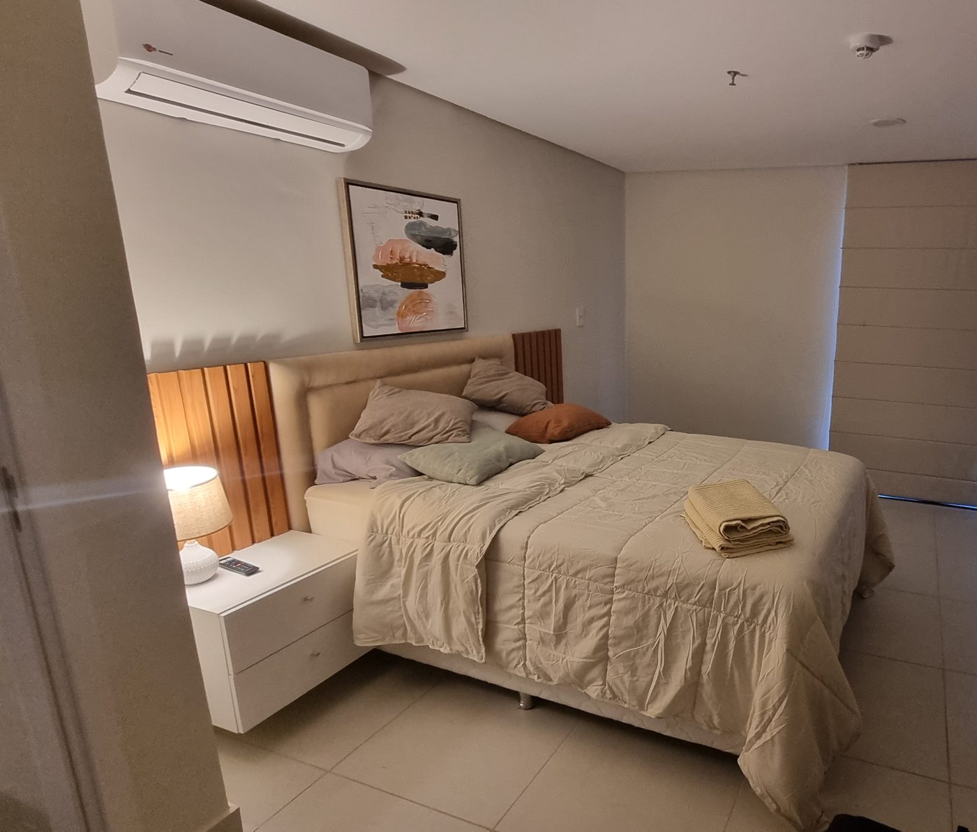 Schlafzimmer mit Klimaanlage, Holzpaneelen und Rollo