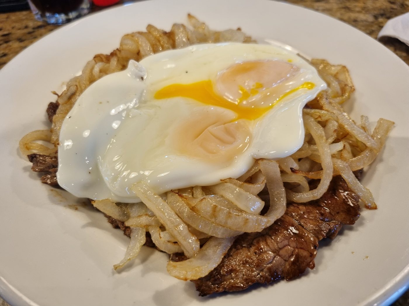 Rindfleisch mit Röstzwiebeln und Spiegelei